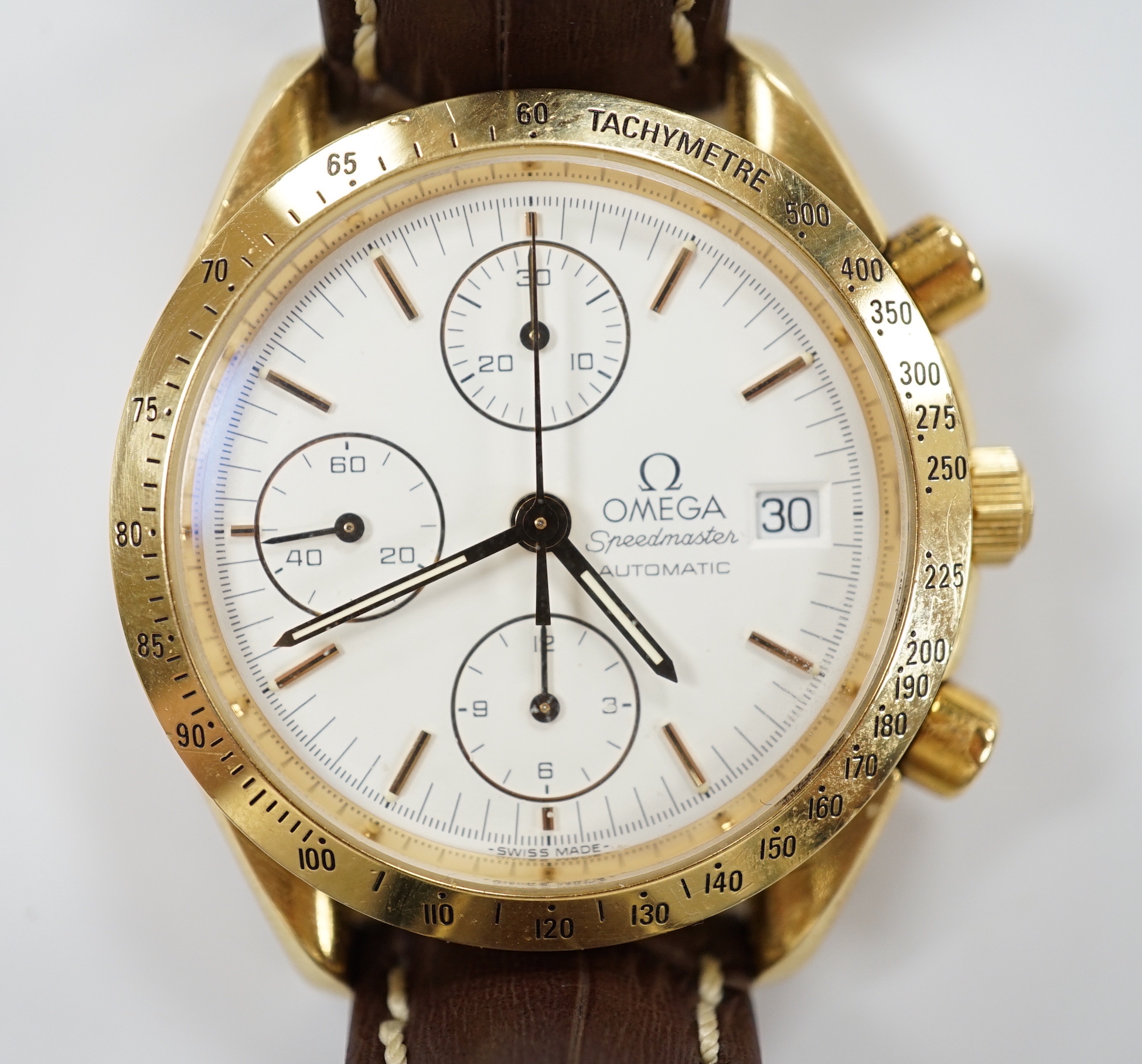 A gentleman's early 1990's 18ct gold Omega Speedmaster automatic wrist watch, with three subsidiary dials, ref. 1155, on later associated leather strap, with gold plated Omega buckle, with box and receipt (second hand).